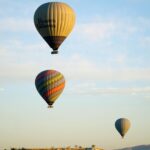 Hot air balloons soaring over the picturesque landscape of Cappadocia at sunrise.